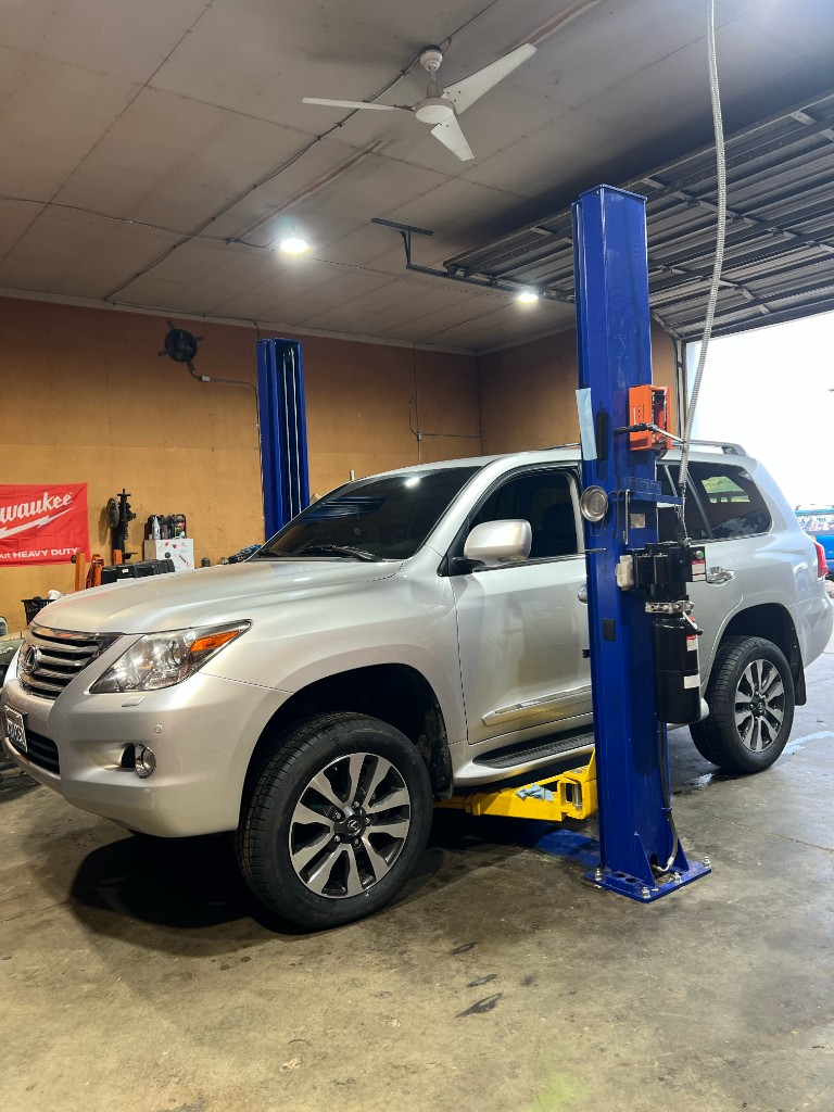 Lexus SUV raised on two-post lift