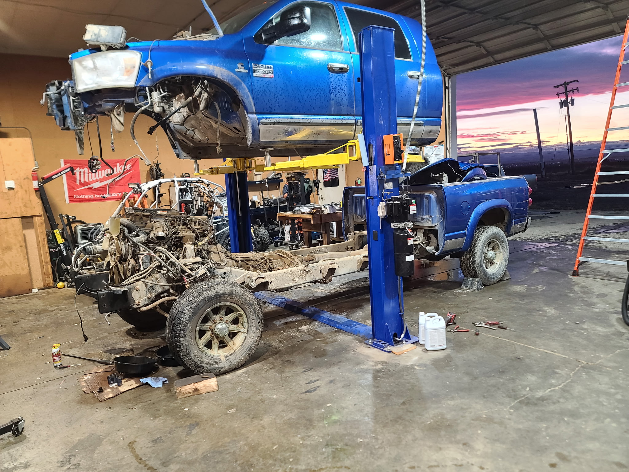 Blue Dodge Ram 2500 cab and bed lifted for chassis repair